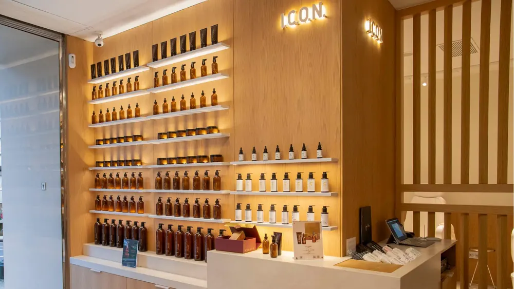 The retail wall of an I.C.O.N. salon store, lit shelves of products under the I.C.O.N. sign