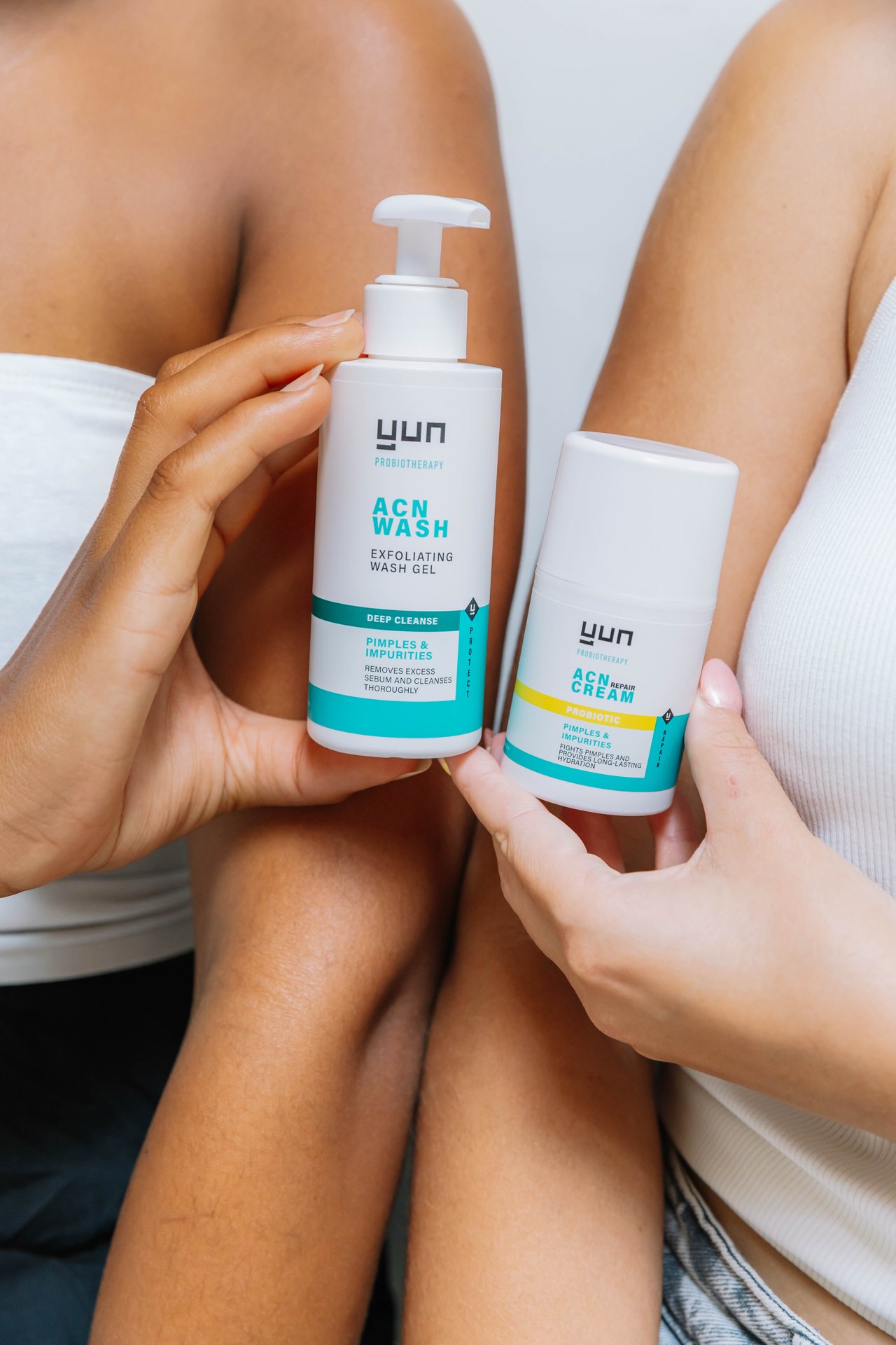 Two people holding YUN ACN Wash and ACN Repair Cream