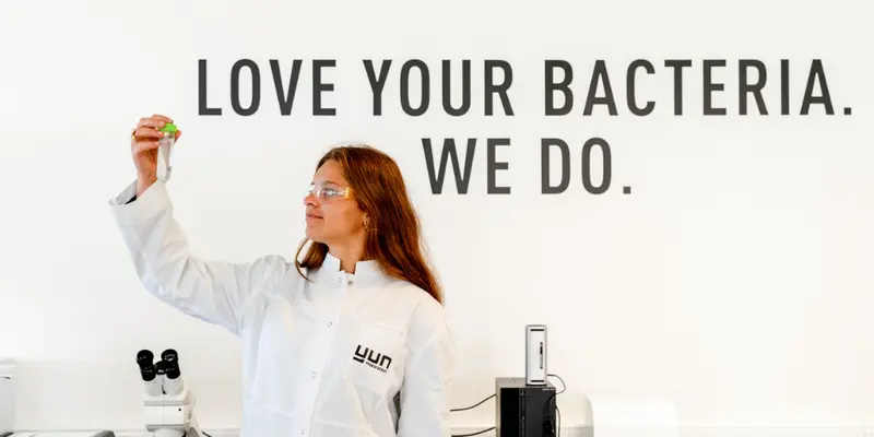 A YUN scientist in the laboratory beneath the words Love your bacteria