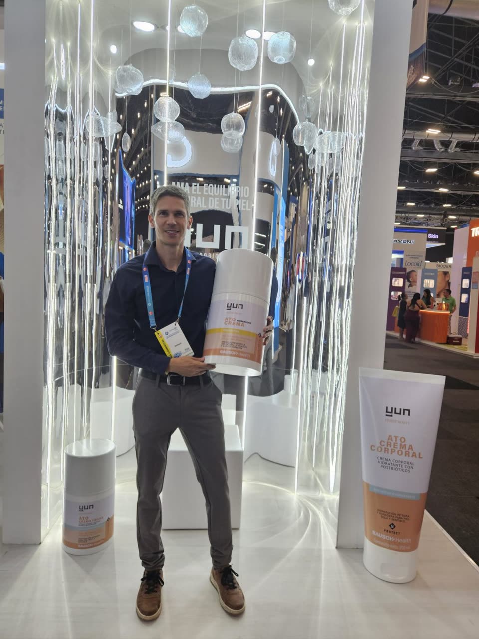 Ingmar Claes holding an ATO repair cream display at the YUN stand