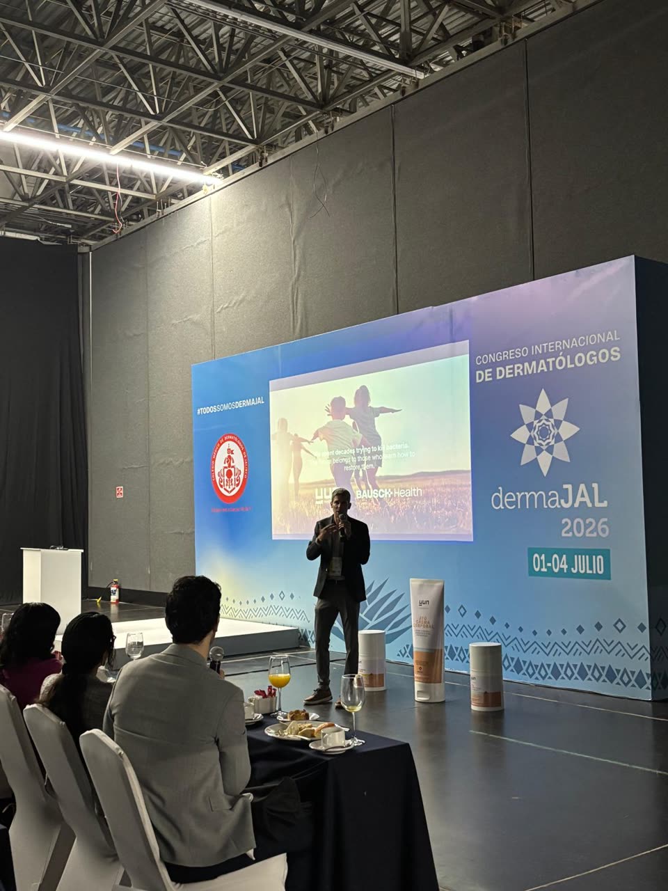 Ingmar Claes presenting YUN and Bausch Health to dermatologists on stage at dermaJAL 2026